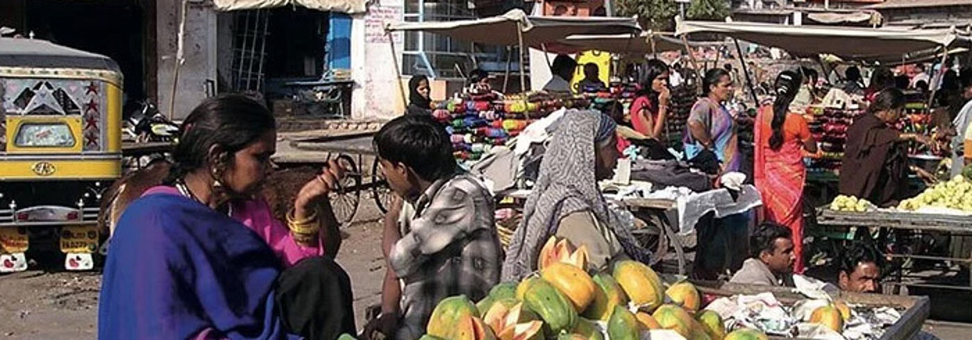 Menschen auf einem indischen Markt kaufen Obst